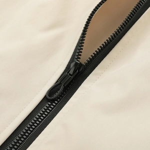 Close-up of black plastic zipper and metal puller on beige casual sport jacket