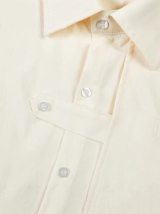 Men's loose textured cream shirt with layered lapel and decorative button strap detail