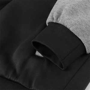 Macro shot of two-tone knit jacket cuffs with black ribbed edge and grey sleeve detail