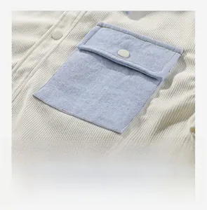Detail der Cordjacke mit hellblauer Denim-Aufsetztasche und Knopfverschluss vorne