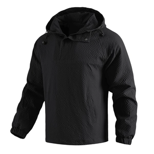 Detailed macro view of black waffle texture fabric on hooded outdoor jacket with drawstring