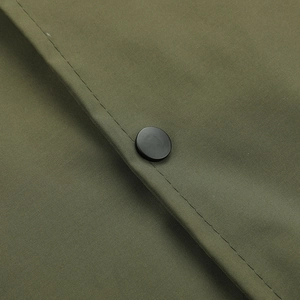 Macro detail of military green jacket stitching and matte black metal snap button