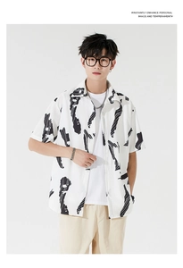 Detail of men's short-sleeved Hawaiian shirt with black abstract art prints on white fabric