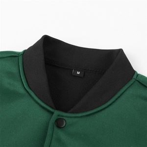 Close-up of dark green jacket showing the black ribbed collar, size M label, and matte button