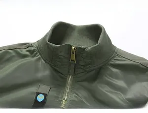 Detail of the olive green flight jacket showing ribbed collar and eagle chest patch