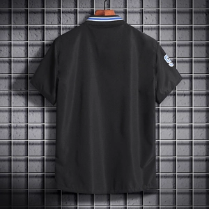 Detail of black polo shirt featuring blue-white striped collar and number 9 embroidery