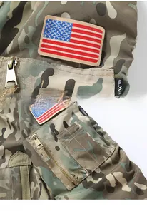 Detailed close-up of embroidered flag patch and tactical zipper arm pocket on camo jacket