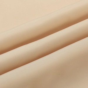 Macro shot showing the fine texture and silk-like sheen of the apricot baseball jacket fabric