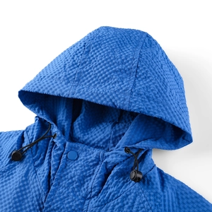 Close-up of blue hooded jacket showing textured seersucker fabric and snap buttons