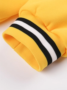 Detail of yellow knit jacket cuff featuring black and white striped elastic ribbed texture