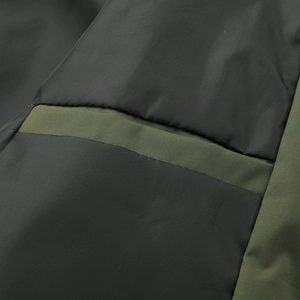Detail shot of windproof jacket fabric with pocket stitching and black-olive contrast
