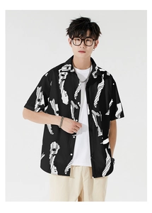 Detail of loose fit men's Hawaiian shirt with white abstract prints on black fabric