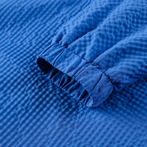 Close-up detail of the elastic cuff and seersucker texture on a royal blue hoodie jacket