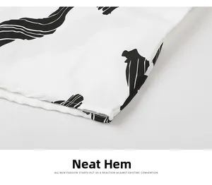 Close-up of the neat hemline stitching on a white Hawaiian shirt with black floral print