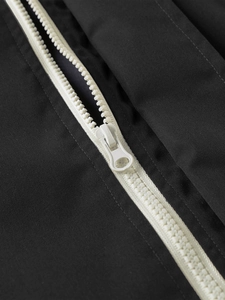 Macro shot of high-contrast white resin zipper on a black windproof men jacket