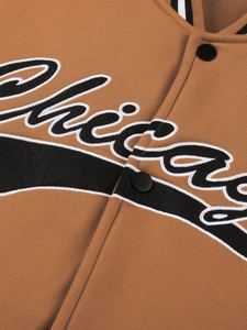 Close-up of the Chicago embroidery and button closure on the brown baseball jacket