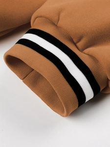 Detailed macro view of camel knit jacket cuff with black and white striped elastic ribbing