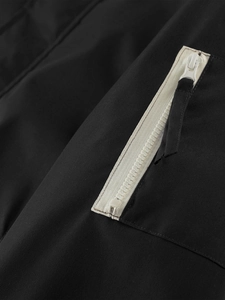 Detailed close-up of side zipper pocket on a black lightweight casual men's jacket