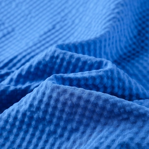 Detailed macro view of the blue waffle textured fabric on a hooded men jacket