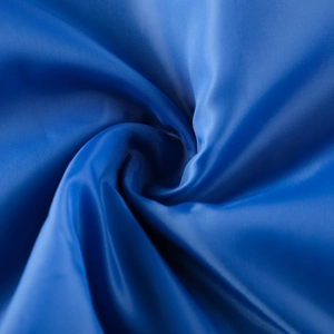 Macro shot of dark blue synthetic fabric with fine woven texture and smooth silky finish