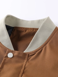 Close-up of brown casual jacket featuring a contrast beige ribbed collar and metal snap button