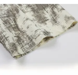 Gros plan du détail des manches en maille côtelée tie-dye sur un t-shirt oversize en V