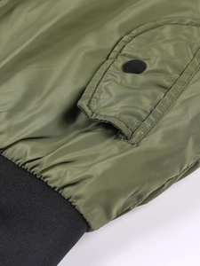 Detail of military green bomber jacket with flap pocket and black ribbed cuffs