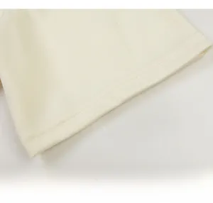 Détail du revers en maille crème avec des coutures doubles propres pour une finition de qualité