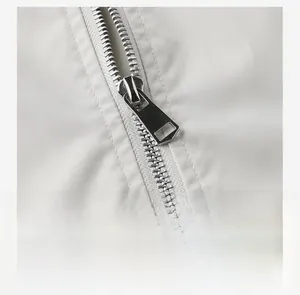 Detail of silver metal zipper and smooth track on white outdoor sports jacket