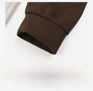 Macro detail of elastic ribbed cuffs on a men's heavy knit dark brown polo sweatshirt