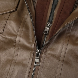 Détail d'une veste en cuir marron avec double fermeture éclair et coutures de qualité