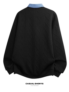 Detail of cable knit pattern and checkered shirt collar on black sweatshirt