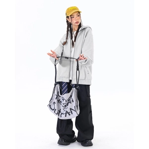 Oversized grauer Kapuzenpullover kombiniert mit schwarzer Cargo-Hose und gelber Kappe