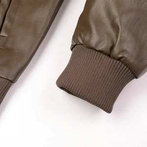 Détails des poignets et de l'ourlet en maille côtelée sur la veste en cuir vert olive
