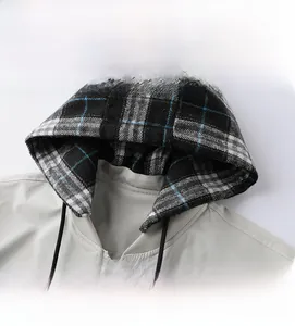 Detail of detachable hood with plaid lining and drawstring on light grey jacket