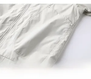 Detail of light gray outdoor jacket with smooth metal zipper and large utility pockets