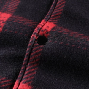 Macro shot of red plaid flannel jacket showing warm fleece texture and black button detail