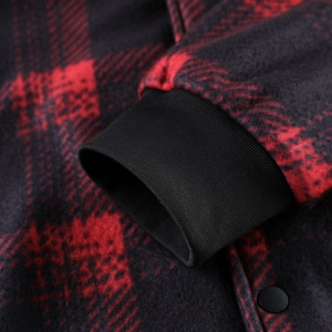 Close-up of red and black plaid fleece jacket featuring ribbed cuffs and matte snap button