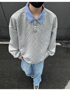 Detailed view of grey cable knit polo sweater featuring a blue plaid collar and metal buttons