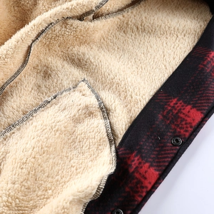 Detail of red and black plaid jacket showing warm beige sherpa fleece lining and metal snaps