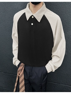 Detail of men's polo sweatshirt featuring black and cream color-block ribbed knit texture