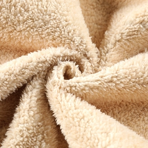 Close-up of thick beige polar fleece fabric with soft texture for winter jackets