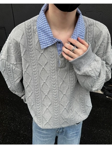 Detail of grey men's knit polo with diamond cable pattern and layered plaid collar style