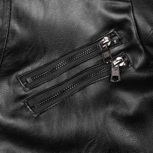 Détail de la veste en cuir noir avec deux fermetures éclair argentées et texture grainée
