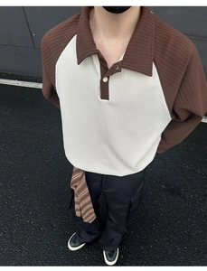 Close-up of brown polo shirt with vertical striped texture and contrast raglan sleeves