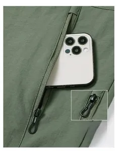 Detail of olive green flight jacket showing a zip pocket and anti-rip grid fabric texture