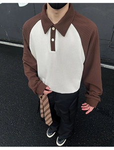 Detail of waffle textured knit and two-button polo collar on color block sweatshirt