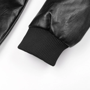 Détail de la manche d'une veste en cuir noir avec poignet élastique en maille côtelée