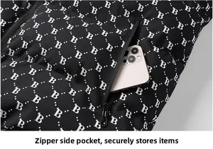 Detail view of the side zipper pocket on a black winter puffer jacket with letter patterns