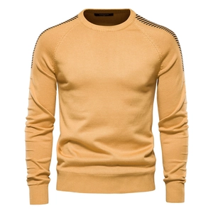 Detail of knit sweater crew neck with black stripes on shoulder and brand label